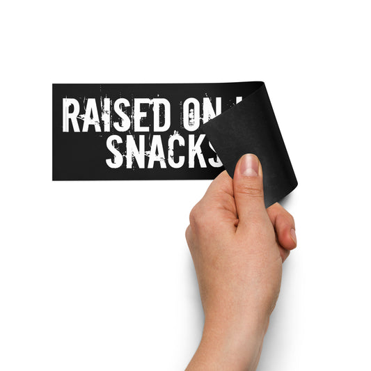 Black car magnet that says "Raised on love, snacks & dirt" in a grungy white font and features a red Voltastra logo in the top right corner being peeled back.