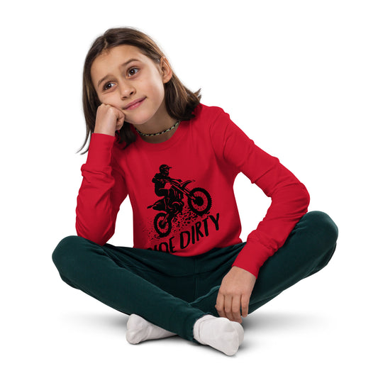 Child wearing a red long-sleeve shirt with black dirt bike graphic and 'Ride Dirty' text, sitting on the floor.