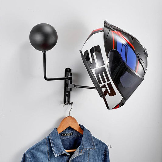 Helmet hanging on a wall-mounted hanger with a denim jacket below on a light gray background