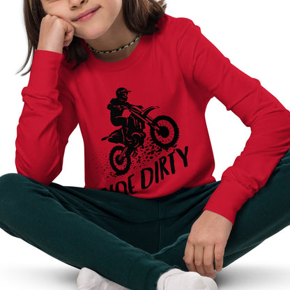 Child wearing a red long-sleeve shirt with black dirt bike graphic and 'Ride Dirty' text, sitting on the floor.